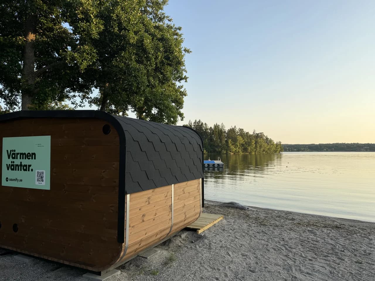Sjöbastun på stranden vid Kaggeholm i gyllene kvällsljus, med Mälaren och bryggan bakom