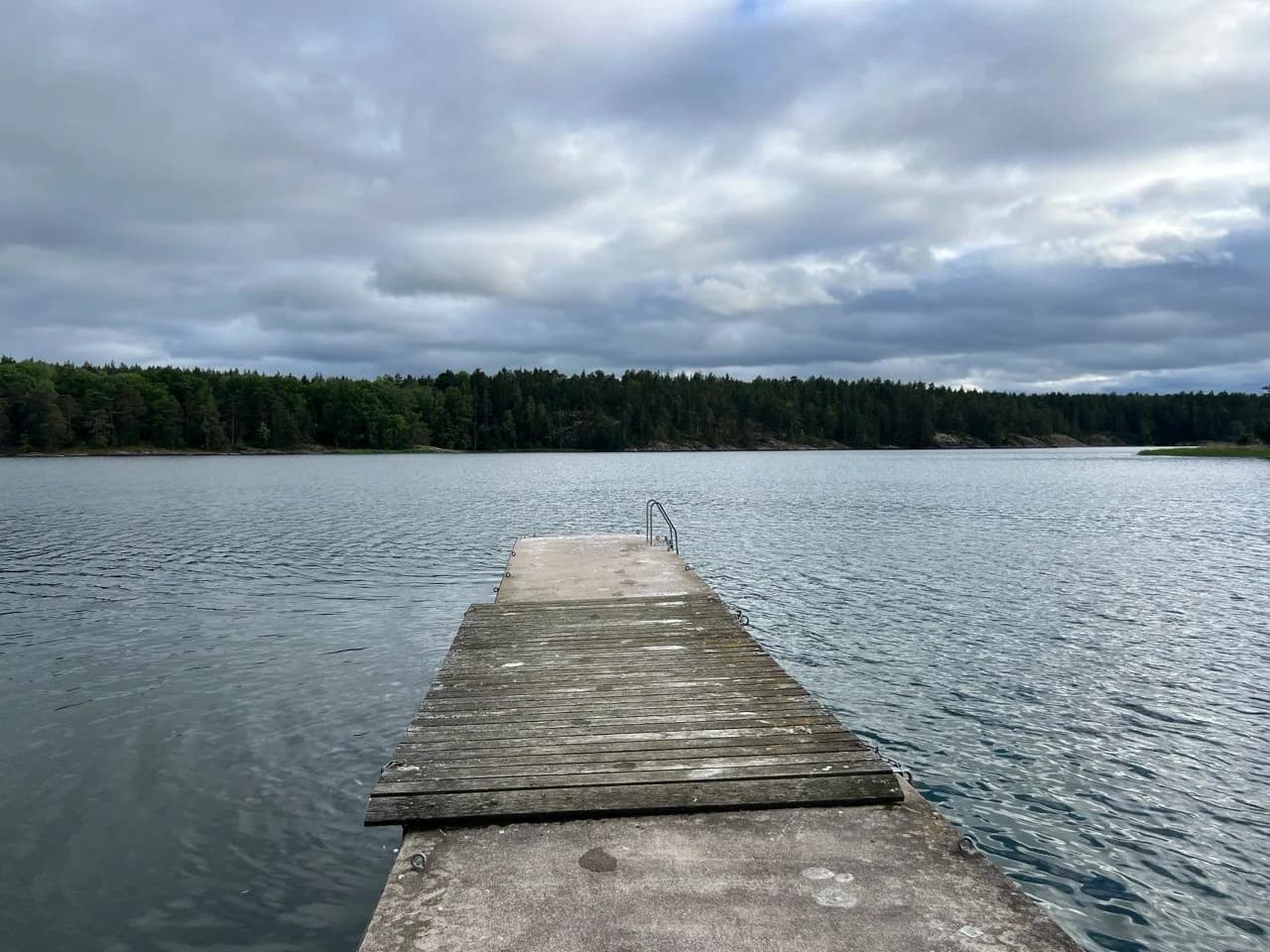 Bryggan med badstege för kallbad vid bastun i Åkersberga, rakt ut i skärgårdsvattnet med skogen bakom